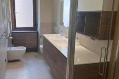 Erretre Ceramiche ristrutturazione bagno appartamento a Milano zona Piazzale Siena. Bagno con muri beige lavabo e mobile bagno con: specchi, water e bidet.