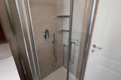 Erretre Ceramiche ristrutturazione bagno appartamento a Milano zona Piazzale Siena, doccia nicchia a due ante battenti in vetro vicino all'ingresso.