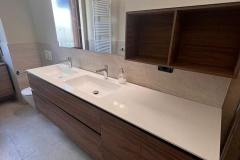 Erretre Ceramiche ristrutturazione bagno appartamento a Milano zona Piazzale Siena, mobile bagno in legno, con piano bianco, doppio lavandino e specchio rettangolare in vetro.