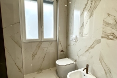 Erretre Ceramiche realizzazione di un bagno moderno in una Villetta a Magenta con bidet e water di colore bianco e pavimenti e pareti rivestiti con piastrelle di colore chiaro