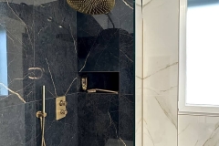 Erretre Ceramiche realizzazione all'interno di un bagno moderno di una villetta a Magenta di un box doccia con pareti scure con fungo ed inserti di colore oro