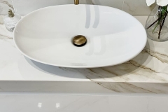 Erretre Ceramiche realizzazione di un bagno moderno in una villetta a Magenta, con lavabo di colore bianco di forma ovale, con pomello ed inserti di colore dorato