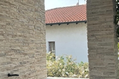 Dettagli parete esterna, colonna e muretto, rivestiti con piastrelle in pietra color Sinai di una villetta unifamiliare a Marcallo