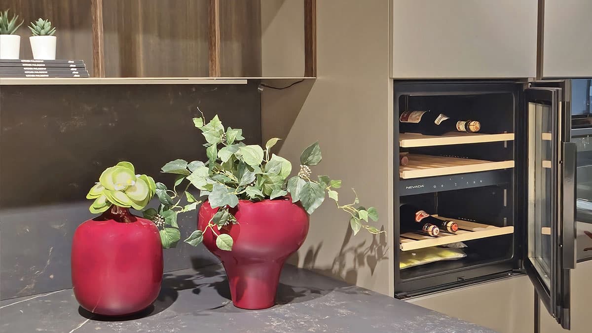 Dettaglio Cantinetta Vini NEFF integrata nella colonna cucina Elmar Modello Slim. Vaso decorativo rosso su top scuro.
