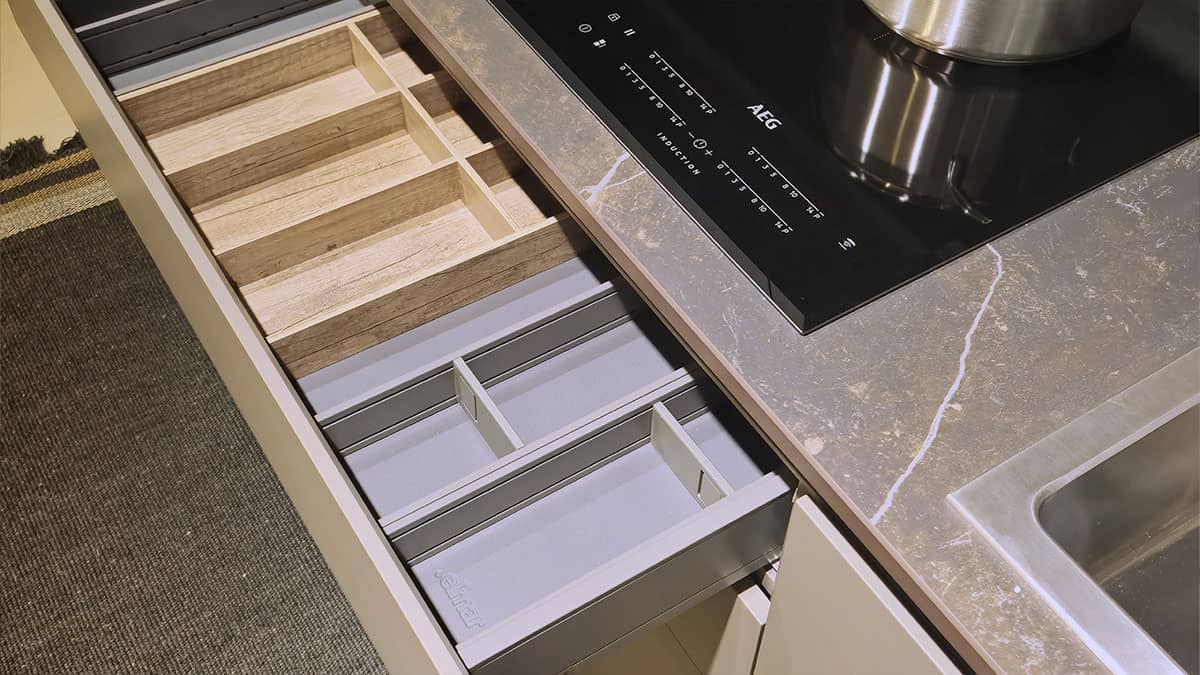 Dettaglio Cassetti interni attrezzati con porta posate, finitura legno chiaro e grigio, nella Cucina Elmar Modello Slim.