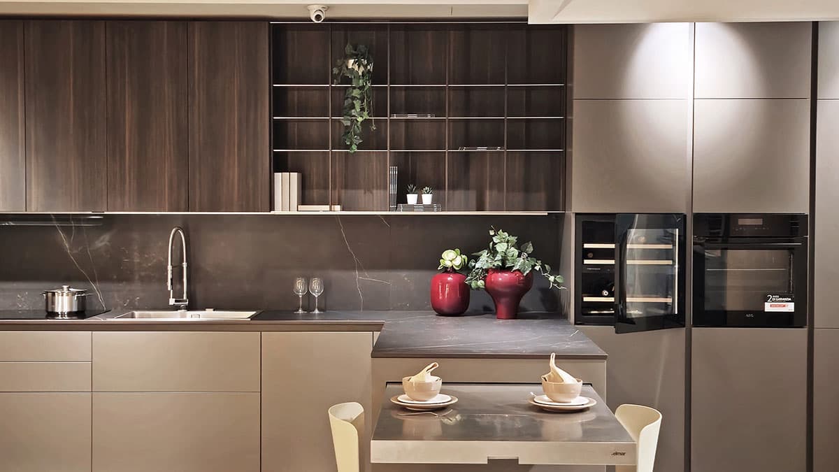 Frontale Cucina Elmar Modello Slim, design moderno con finiture grigio tortora e pensili in legno scuro. Dettaglio cantinetta vini e tavolo integrato.
